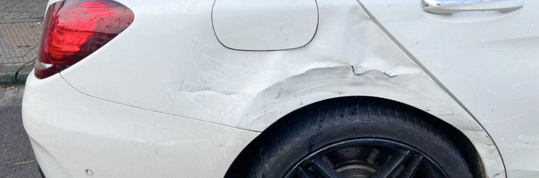rear right of a white mercedes with major damage to its side.